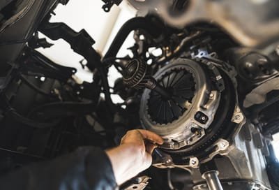 closeup shot of an auto mechanic installing a new clutch kit for a car, auto repair shop. High quality photo