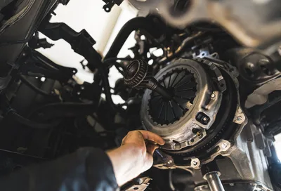closeup shot of an auto mechanic installing a new clutch kit for a car, auto repair shop closeup shot of an auto mechanic installing a new clutch kit for a car, auto repair shop. High quality photo